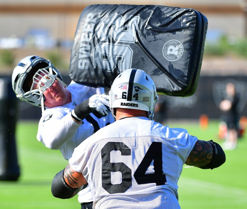 Jul 28, 2021; Las Vegas, NV, USA; Las Vegas Raiders guard Richie Incognito (64) puts a hit on tackle Sam Young (79) during a team practice at Intermountain Healthcare Performance Center in Henderson. Mandatory Credit: Stephen R. Sylvanie-USA TODAY Sports