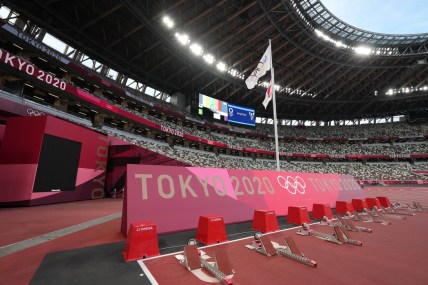 Jul 29, 2021; Tokyo, Japan; A general overall view of the starting blocks on the track and Olympic rings and Japan flags at New National Stadium, the venue for track and field and opening and closing ceremonies during the Tokyo 2020 Olympic Summer Games. Mandatory Credit: Kirby Lee-USA TODAY Sports
