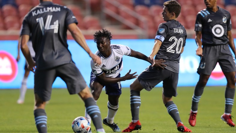 Jul 31, 2021; Sandy, Utah, USA; Vancouver Whitecaps midfielder Janio Bikel (19) and Minnesota United midfielder Will Trapp (20) play for a ball in the first half at Rio Tinto Stadium. Mandatory Credit: Rob Gray-USA TODAY Sports