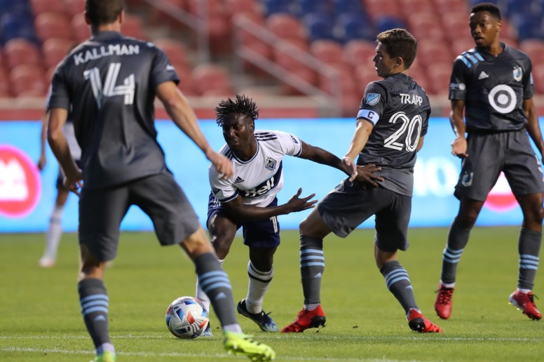 Jul 31, 2021; Sandy, Utah, USA; Vancouver Whitecaps midfielder Janio Bikel (19) and Minnesota United midfielder Will Trapp (20) play for a ball in the first half at Rio Tinto Stadium. Mandatory Credit: Rob Gray-USA TODAY Sports