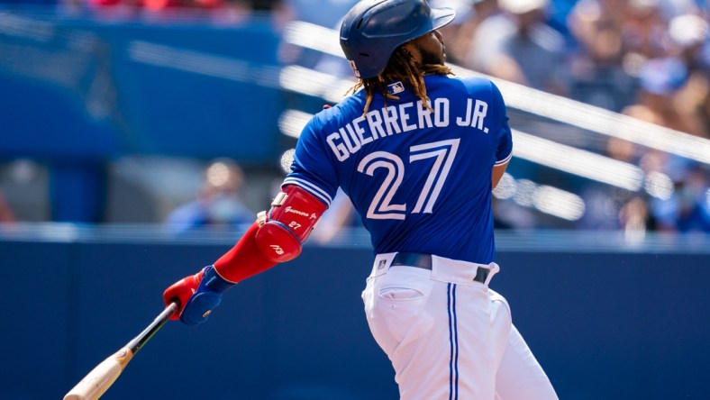 Aug 2, 2021; Toronto, Ontario, CAN; Toronto Blue Jays first baseman Vladimir Guerrero Jr. (27) hits a single against the Cleveland Indians during the first inning at Rogers Centre. Mandatory Credit: Kevin Sousa-USA TODAY Sports