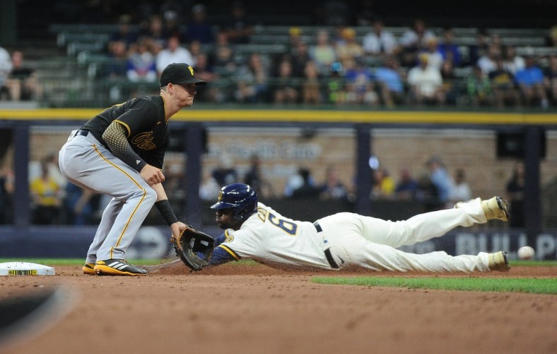 Aug 2, 2021; Milwaukee, Wisconsin, USA;  Milwaukee Brewers center fielder Lorenzo Cain (6) slides safely into second base ahead of the tag by Pittsburgh Pirates shortstop Kevin Newman (27) in the third inning at American Family Field. Mandatory Credit: Michael McLoone-USA TODAY Sports