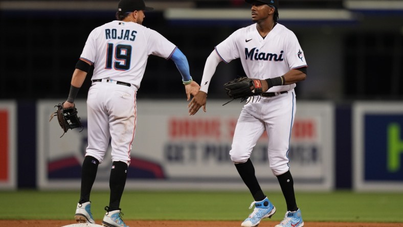 Aug 2, 2021; Miami, Florida, USA; Miami Marlins shortstop Miguel Rojas (19) and center fielder Lewis Brinson (25) celebrate after defeating the New York Mets at loanDepot park. Mandatory Credit: Jasen Vinlove-USA TODAY Sports