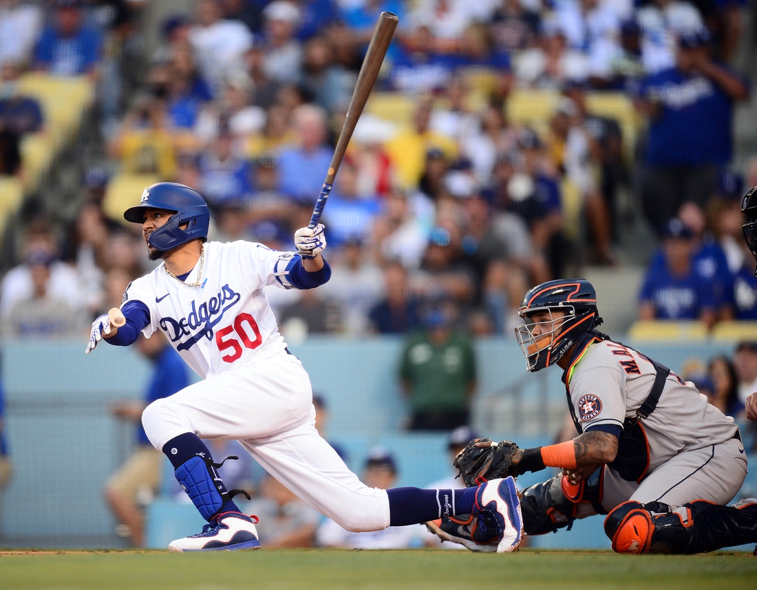 Aug 3, 2021; Los Angeles, California, USA; Los Angeles Dodgers second baseman Mookie Betts (50) hits a single against the Houston Astros during the first inning at Dodger Stadium. Mandatory Credit: Gary A. Vasquez-USA TODAY Sports