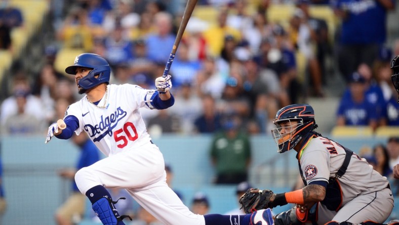 Aug 3, 2021; Los Angeles, California, USA; Los Angeles Dodgers second baseman Mookie Betts (50) hits a single against the Houston Astros during the first inning at Dodger Stadium. Mandatory Credit: Gary A. Vasquez-USA TODAY Sports