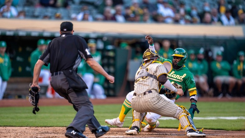 Aug 3, 2021; Oakland, California, USA; Oakland Athletics second baseman Josh Harrison (1) is tagged out at home plate by San Diego Padres catcher Austin Nola (26) during the second inning at RingCentral Coliseum. Mandatory Credit: Neville E. Guard-USA TODAY Sports