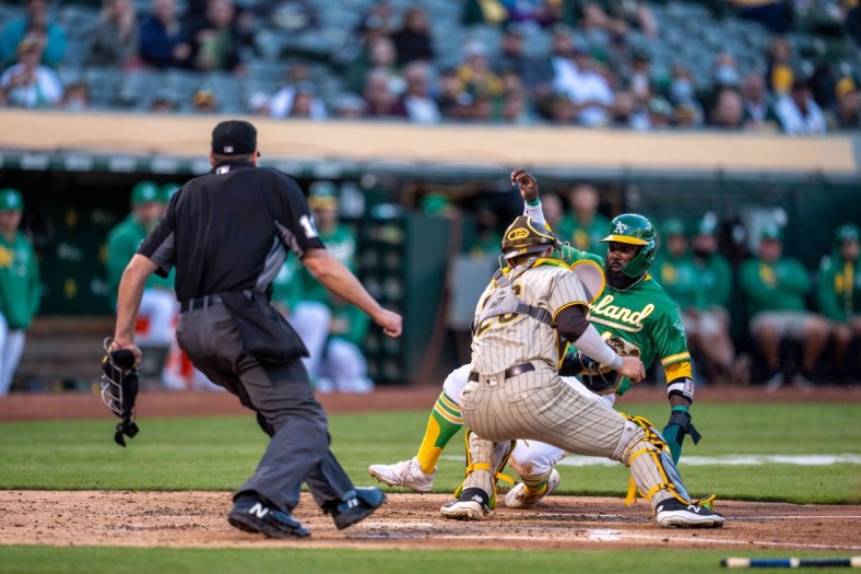 Aug 3, 2021; Oakland, California, USA; Oakland Athletics second baseman Josh Harrison (1) is tagged out at home plate by San Diego Padres catcher Austin Nola (26) during the second inning at RingCentral Coliseum. Mandatory Credit: Neville E. Guard-USA TODAY Sports