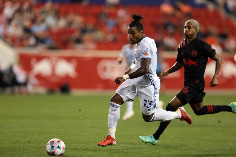 Aug 4, 2021; Harrison, New Jersey, USA; FC Cincinnati midfielder Joseph-Claude Gyau (13) moves the ball up the pitch against New York Red Bulls midfielder Dru Yearwood (16) during the first half at Red Bull Arena. Mandatory Credit: Vincent Carchietta-USA TODAY Sports