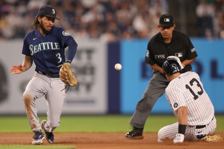 Aug 5, 2021; Bronx, New York, USA; New York Yankees left fielder Joey Gallo (13) slides into second base with a double before Seattle Mariners shortstop J.P. Crawford (3) receives the throw during the fourth inning at Yankee Stadium. Mandatory Credit: Brad Penner-USA TODAY Sports