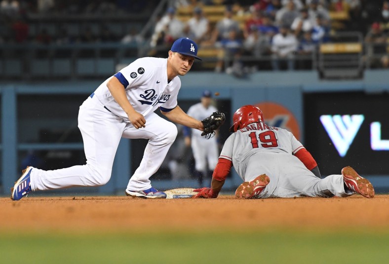 Aug 6, 2021; Los Angeles, California, USA; Los Angeles Angels center fielder Juan Lagares (19) is caught stealing second against Los Angeles Dodgers shortstop Corey Seager (5) during the fifth inning at Dodger Stadium. Mandatory Credit: Richard Mackson-USA TODAY Sports