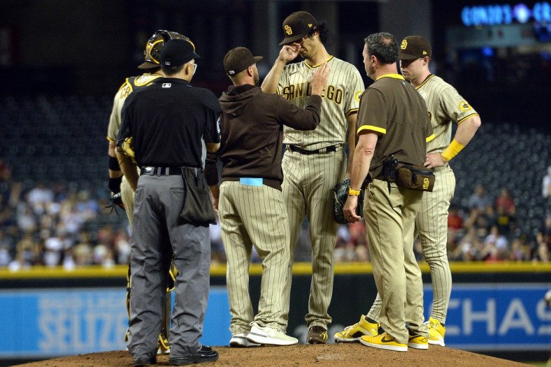 Aug 12, 2021; Phoenix, Arizona, USA; San Diego Padres starting pitcher Yu Darvish (11) reacts as he is taken out of the game by manager Jayce Tingler (brown jacket) after suffering an apparent injury during the third inning against the Arizona Diamondbacks at Chase Field. Mandatory Credit: Joe Camporeale-USA TODAY Sports