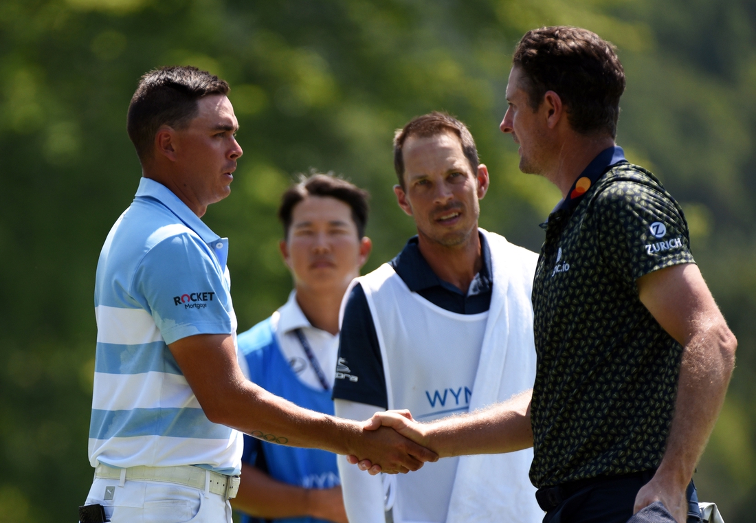 Aug 13, 2021; Greensboro, North Carolina, USA; Justin Rose (far right) shakes hands with Rickie Fowler after completing  the second round of the Wyndham Championship golf tournament. Mandatory Credit: Rob Kinnan-USA TODAY Sports