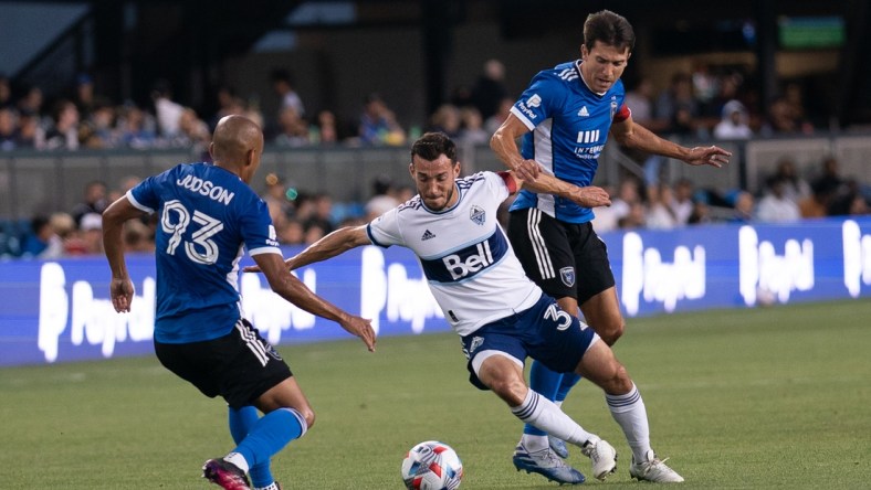 Aug 13, 2021; San Jose, California, USA; Vancouver Whitecaps midfielder Russell Teibert (31) fights for control of the ball against San Jose Earthquakes midfielder Judson (93) and defender Tanner Beason (15) during the first half at PayPal Park. Mandatory Credit: Stan Szeto-USA TODAY Sports