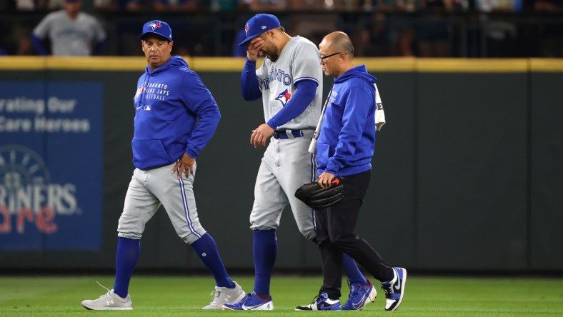 Aug 14, 2021; Seattle, Washington, USA; Toronto Blue Jays center fielder George Springer (4) reacts while exiting the game after suffering an apparent injury to his lower leg while attempting to make a plain a ball hit for a triple by Seattle Mariners first baseman Ty France (not pictured) during the seventh inning at T-Mobile Park. Mandatory Credit: Abbie Parr-USA TODAY Sports