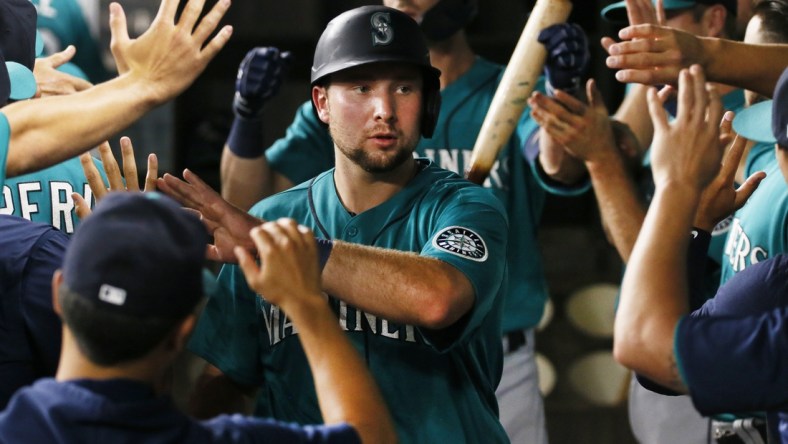 Aug 17, 2021; Arlington, Texas, USA; Seattle Mariners catcher Cal Raleigh (29) is greeted in the dugout after scoring against the Texas Rangers during the fifth inning at Globe Life Field. Mandatory Credit: Raymond Carlin III-USA TODAY Sports