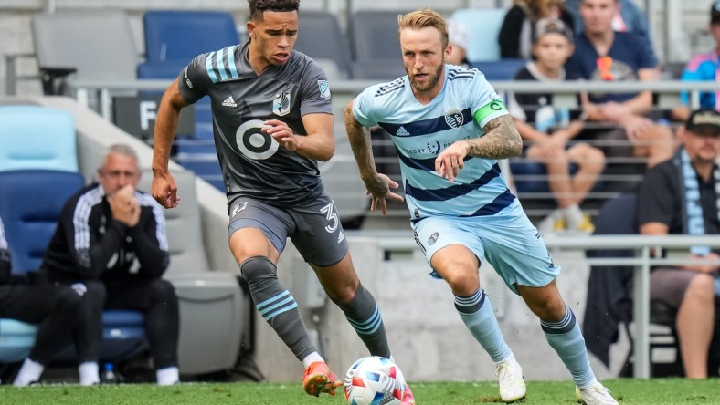 Aug 21, 2021; Saint Paul, MN, USA; Sporting Kansas City forward Johnny Russell (7) dribbles past Minnesota United midfielder Hassani Dotson (31) during the first half at Allianz Field. Mandatory Credit: Brace Hemmelgarn-USA TODAY Sports