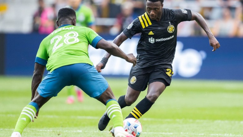 Aug 21, 2021; Columbus, Ohio, USA;  Columbus Crew midfielder Derrick Etienne (22) dribbles the ball while Seattle Sounders defender Yeimar Gomez (28) defends in the first half at Lower.com Stadium. Mandatory Credit: Trevor Ruszkowski-USA TODAY Sports