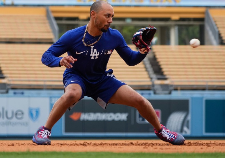 Aug 22, 2021; Los Angeles, California, USA; Los Angeles Dodgers All-Star outfielder Mookie Betts works out at third base before the Dodgers game against the New York Mets at Dodger Stadium. Betts has been on the injury list since Aug. 8 with a bone spur in his hip. Mandatory Credit: Robert Hanashiro-USA TODAY Sports