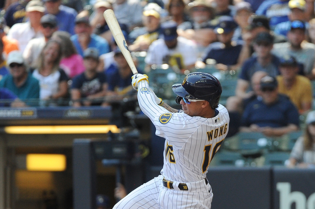 Aug 22, 2021; Milwaukee, Wisconsin, USA; Milwaukee Brewers second baseman Kolten Wong (16) hits a triple to score two run against the Washington Nationals in the fourth inning at American Family Field. Mandatory Credit: Michael McLoone-USA TODAY Sports