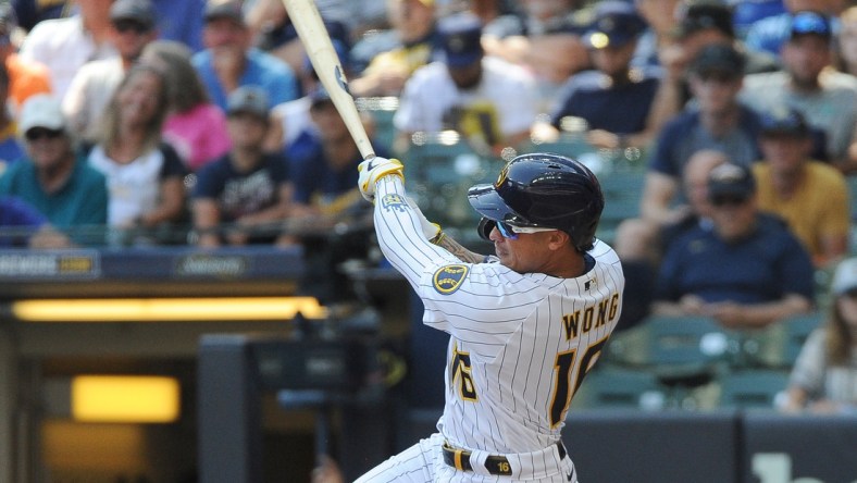 Aug 22, 2021; Milwaukee, Wisconsin, USA; Milwaukee Brewers second baseman Kolten Wong (16) hits a triple to score two run against the Washington Nationals in the fourth inning at American Family Field. Mandatory Credit: Michael McLoone-USA TODAY Sports