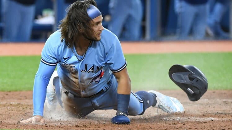 Aug 23, 2021; Toronto, Ontario, CAN;  Toronto Blue Jays shortstop Bo Bichette (11) slides home to score against the Chicago White Sox in the sixth inning at Rogers Centre. Mandatory Credit: Dan Hamilton-USA TODAY Sports
