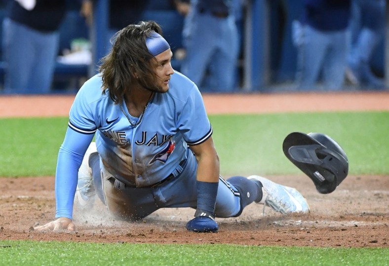 Aug 23, 2021; Toronto, Ontario, CAN;  Toronto Blue Jays shortstop Bo Bichette (11) slides home to score against the Chicago White Sox in the sixth inning at Rogers Centre. Mandatory Credit: Dan Hamilton-USA TODAY Sports