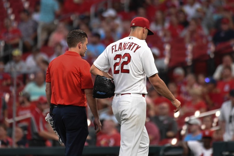 Aug 24, 2021; St. Louis, Missouri, USA; St. Louis Cardinals starting pitcher Jack Flaherty (22) leaves the field with a trainer after being pulled from the game against the Detroit Tigers during the third inning at Busch Stadium. Mandatory Credit: Joe Puetz-USA TODAY Sports