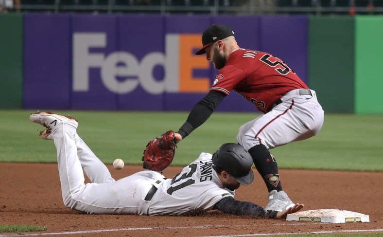 Aug 25, 2021; Pittsburgh, Pennsylvania, USA;  Pittsburgh Pirates second baseman Michael Chavis (31) dives back safely to first base as Arizona Diamondbacks first baseman Christian Walker (53) takes a pick-off attempt how during the fifth inning at PNC Park. Mandatory Credit: Charles LeClaire-USA TODAY Sports