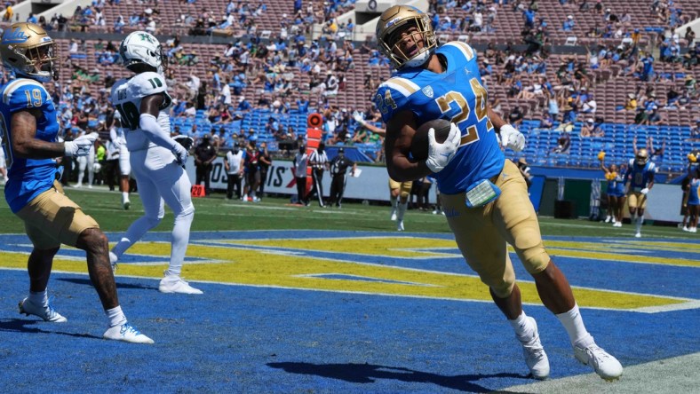 Aug 28, 2021; Pasadena, California, USA;  UCLA Bruins running back Zach Charbonnet (24) scores on a 21-yard touchdown run in the second quarter against the Hawaii Rainbow Warriors at Rose Bowl. Mandatory Credit: Kirby Lee-USA TODAY Sports