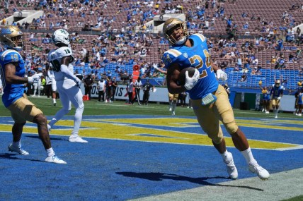 Aug 28, 2021; Pasadena, California, USA;  UCLA Bruins running back Zach Charbonnet (24) scores on a 21-yard touchdown run in the second quarter against the Hawaii Rainbow Warriors at Rose Bowl. Mandatory Credit: Kirby Lee-USA TODAY Sports