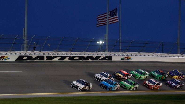 Aug 28, 2021; Daytona Beach, Florida, USA;  NASCAR Cup Series driver Denny Hamlin (11) leads through the turn for the Coke Zero 400 at Daytona International Speedway. Mandatory Credit: Nathan Ray Seebeck-USA TODAY Sports