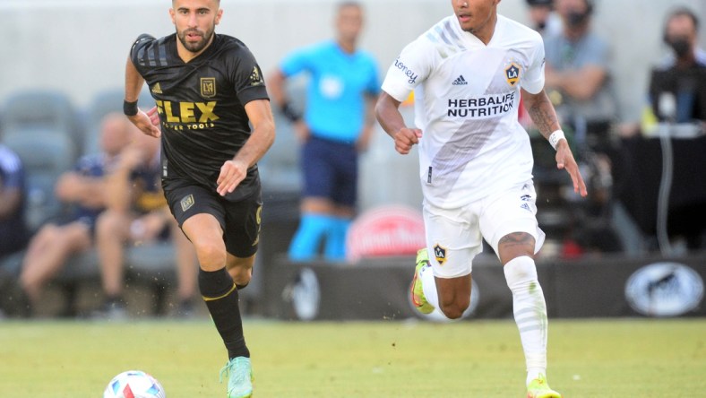 Aug 28, 2021; Los Angeles, CA, Los Angeles, CA, USA; Los Angeles FC forward Diego Rossi (9) moves the ball against Los Angeles Galaxy defender Julian Araujo (2) during the second half at Banc of California Stadium. Mandatory Credit: Gary A. Vasquez-USA TODAY Sports