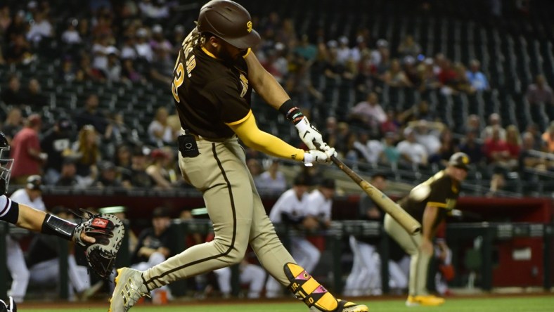 Aug 30, 2021; Phoenix, Arizona, USA;  San Diego Padres shortstop Fernando Tatis Jr. (23) hits a two run home run in the first inning against the Arizona Diamondbacks at Chase Field. Mandatory Credit: Matt Kartozian-USA TODAY Sports