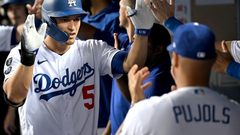 Aug 30, 2021; Los Angeles, California, USA;  Los Angeles Dodgers shortstop Corey Seager (5) is greeted in the dugout after hitting a two run home scoring left fielder AJ Pollock (11) run in the third inning of the game against the Atlanta Braves at Dodger Stadium. Mandatory Credit: Jayne Kamin-Oncea-USA TODAY Sports