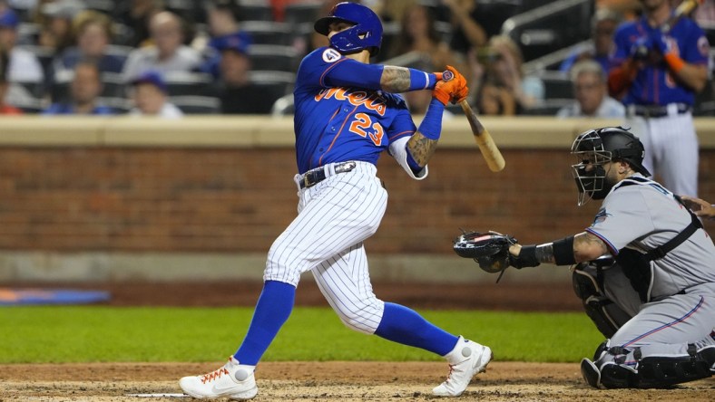 Aug 31, 2021; New York City, New York, USA; New York Mets shortstop Javier Baez (23) hits a single against the Miami Marlins during the fourth inning at Citi Field. Mandatory Credit: Gregory Fisher-USA TODAY Sports