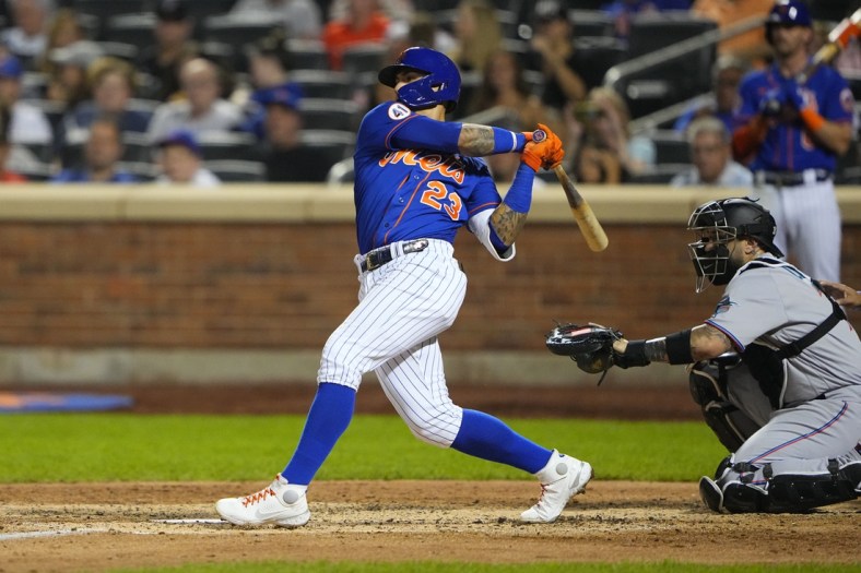 Aug 31, 2021; New York City, New York, USA; New York Mets shortstop Javier Baez (23) hits a single against the Miami Marlins during the fourth inning at Citi Field. Mandatory Credit: Gregory Fisher-USA TODAY Sports