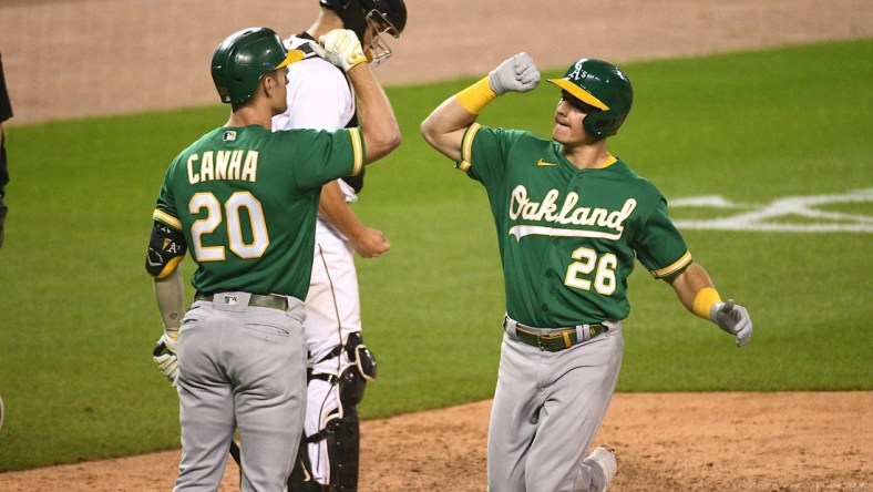 Aug 31, 2021; Detroit, Michigan, USA; Oakland Athletics third baseman Matt Chapman (26) celebrates with left fielder Mark Canha (20) after hitting a home run against the Detroit Tigers during the ninth inning at Comerica Park. Mandatory Credit: Tim Fuller-USA TODAY Sports