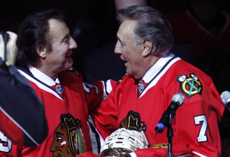 Former Chicago Blackhawks goaltender Tony Esposito (L) is greeted by his brother Phil during a pre-game ceremony before the NHL hockey game between the Washington Capitals and Chicago Blackhawks in Chicago, March 19, 2008. REUTERS/Frank Polich (UNITED STATES)