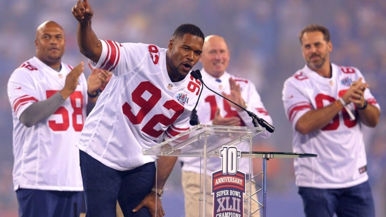 Sep 18, 2017; East Rutherford, NJ, USA; Former New York Giants player Michael Strahan speaks in front of former players Antonio Pierce (58) and Jeff Feagles (18) and Shaun O'Hara (60) during a halftime ceremony honoring the 2007 Super Bowl champion Giants during a game against the Detroit Lions at MetLife Stadium. Mandatory Credit: Brad Penner-USA TODAY Sports