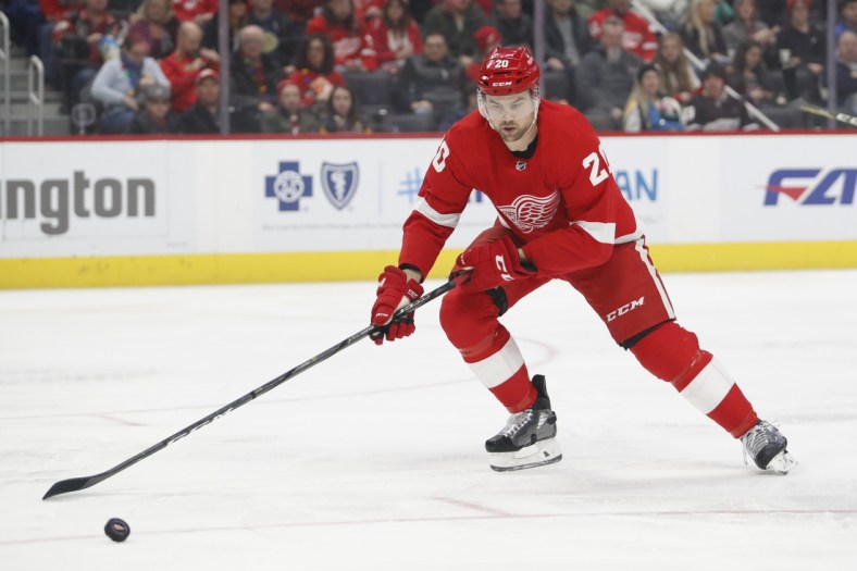 Dec 7, 2019; Detroit, MI, USA; Detroit Red Wings defenseman Dylan McIlrath (20) gets to the loose puck during the first period against the Pittsburgh Penguins at Little Caesars Arena. Mandatory Credit: Raj Mehta-USA TODAY Sports