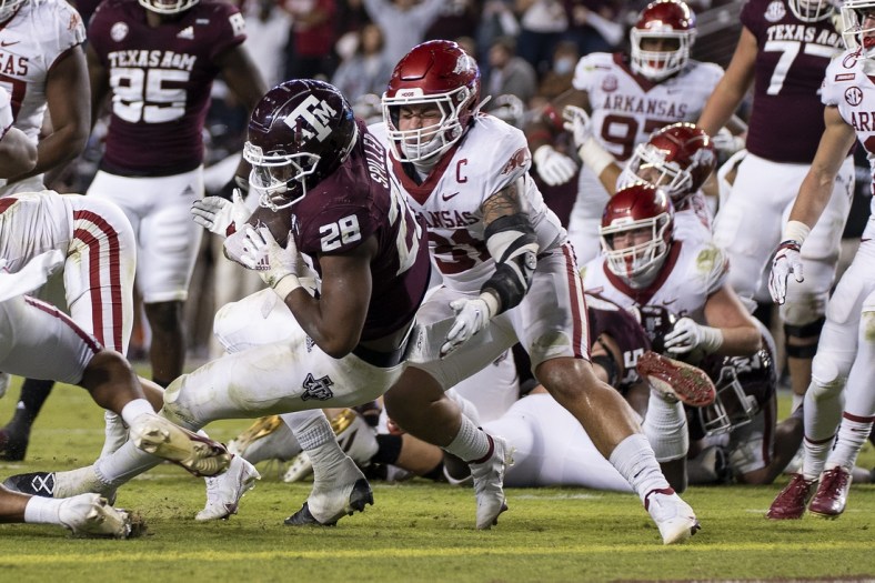 Oct 31, 2020; College Station, TX, USA; Texas A&M running back Isaiah Spiller (28) rushes for a touchdown against Arkansas linebacker Grant Morgan (31) during the second quarter of an NCAA college football game, Saturday, Oct. 31, 2020, in College Station, Texas. Mandatory Credit: Sam Craft/Pool Photo-USA TODAY Sports