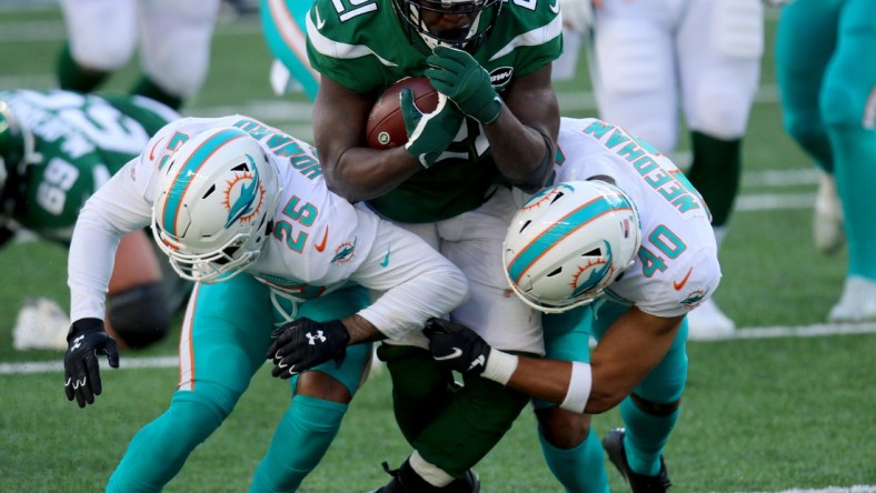 Nov 29, 2020; East Rutherford, New Jersey, USA; New York Jets running back Frank Gore (21) runs against Miami Dolphins cornerback Xavien Howard (25) and defensive back Nik Needham (40) during the first half at MetLife Stadium. Mandatory Credit: Kevin Wexler-USA TODAY Sports