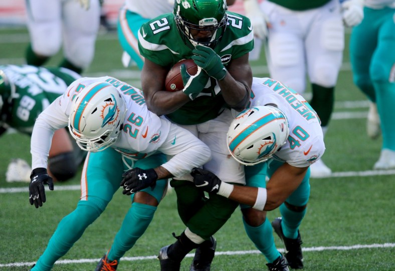 Nov 29, 2020; East Rutherford, New Jersey, USA; New York Jets running back Frank Gore (21) runs against Miami Dolphins cornerback Xavien Howard (25) and defensive back Nik Needham (40) during the first half at MetLife Stadium. Mandatory Credit: Kevin Wexler-USA TODAY Sports