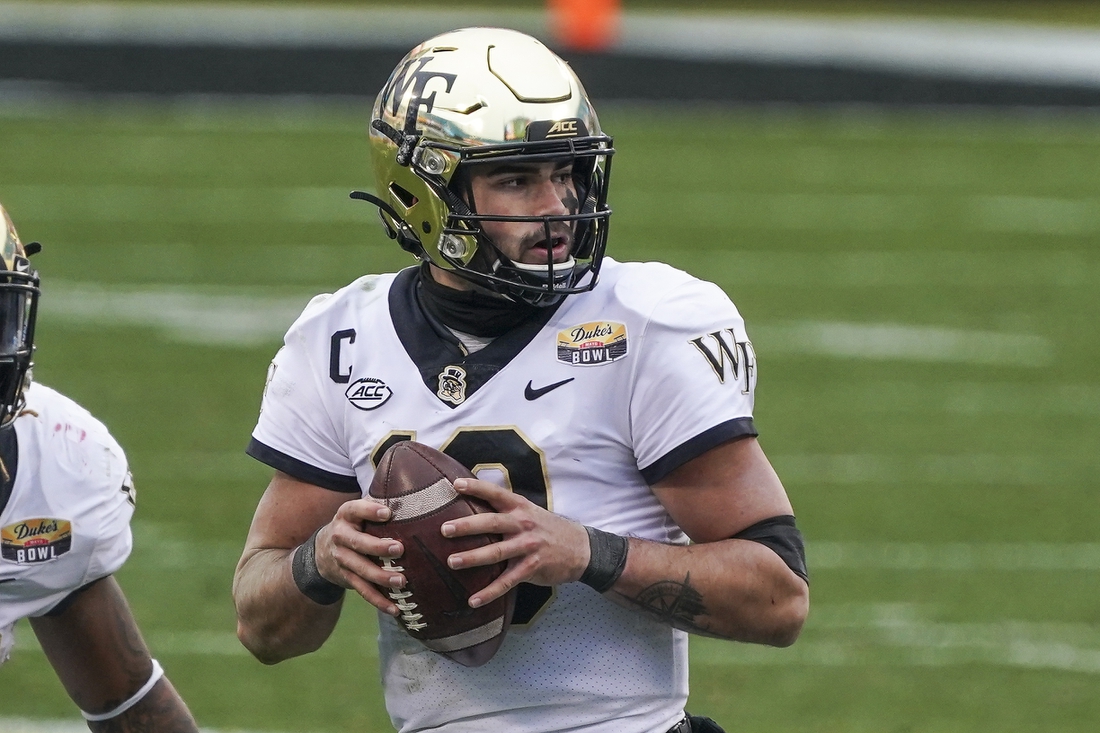 Dec 30, 2020; Charlotte, NC, USA; Wake Forest Demon Deacons quarterback Sam Hartman (10) drops back to pass against the Wisconsin Badgers during second half action at Bank of America Stadium. Mandatory Credit: Jim Dedmon-USA TODAY Sports