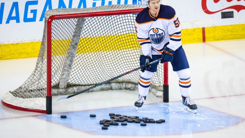 Apr 10, 2021; Calgary, Alberta, CAN; Edmonton Oilers right wing Kailer Yamamoto (56) passes pucks during the warmup period against the Calgary Flames at Scotiabank Saddledome. Mandatory Credit: Sergei Belski-USA TODAY Sports