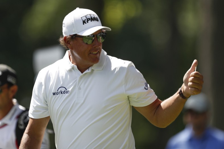 Jul 2, 2021; Detroit, Michigan, USA; Phil Mickelson gives fans a thumbs up as he walks off the 12th tee box during the second round of the Rocket Mortgage Classic golf tournament. Mandatory Credit: Raj Mehta-USA TODAY Sports