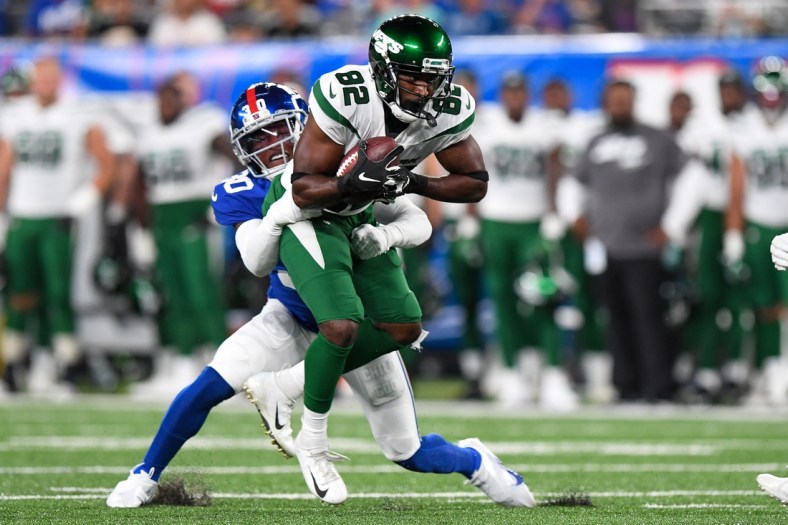 Aug 14, 2021; East Rutherford, New Jersey, USA; New York Jets wide receiver Jamison Crowder (82) runs the ball against New York Giants cornerback Darnay Holmes (30) during the first half at MetLife Stadium. Mandatory Credit: Dennis Schneidler-USA TODAY Sports