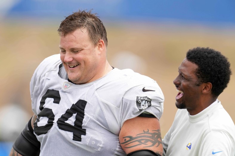 Aug 18, 2021; Thousand Oaks, CA, USA; Las Vegas Raiders  guard Richie Incognito (64) interacts with Los Angeles Rams vice president of communications Artis Twyman during a joint practice. Mandatory Credit: Kirby Lee-USA TODAY Sports