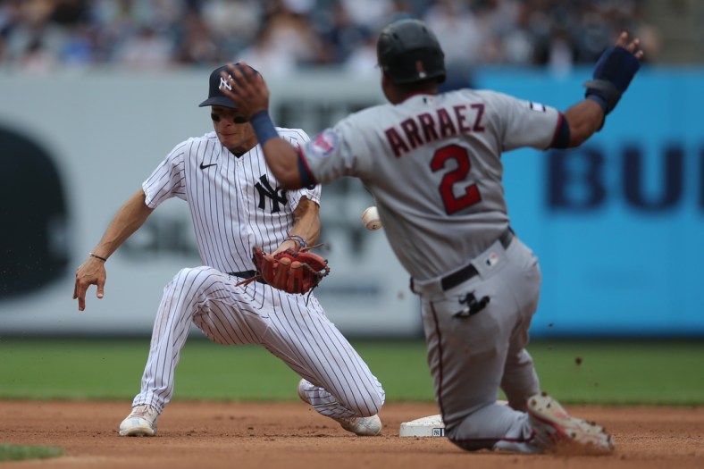 Aug 21, 2021; Bronx, New York, USA; Minnesota Twins third baseman Luis Arraez (2) steals second base as New York Yankees shortstop Andrew Velazquez (71) mishandles the throw during the fourth inning at Yankee Stadium. Mandatory Credit: Brad Penner-USA TODAY Sports
