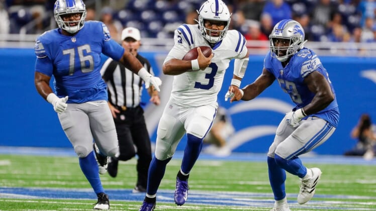 Indianapolis Colts quarterback Brett Hundley (3) runs against Detroit Lions defensive end Bruce Hector (76) and  linebacker Charles Harris (53) during the second half of a preseason game at Ford Field in Detroit on Friday, Aug. 27, 2021.